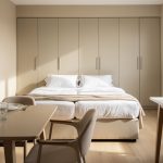 Appartement meublé lumineux avec table équipée, lit, rangements et dossier posé sur un bureau
